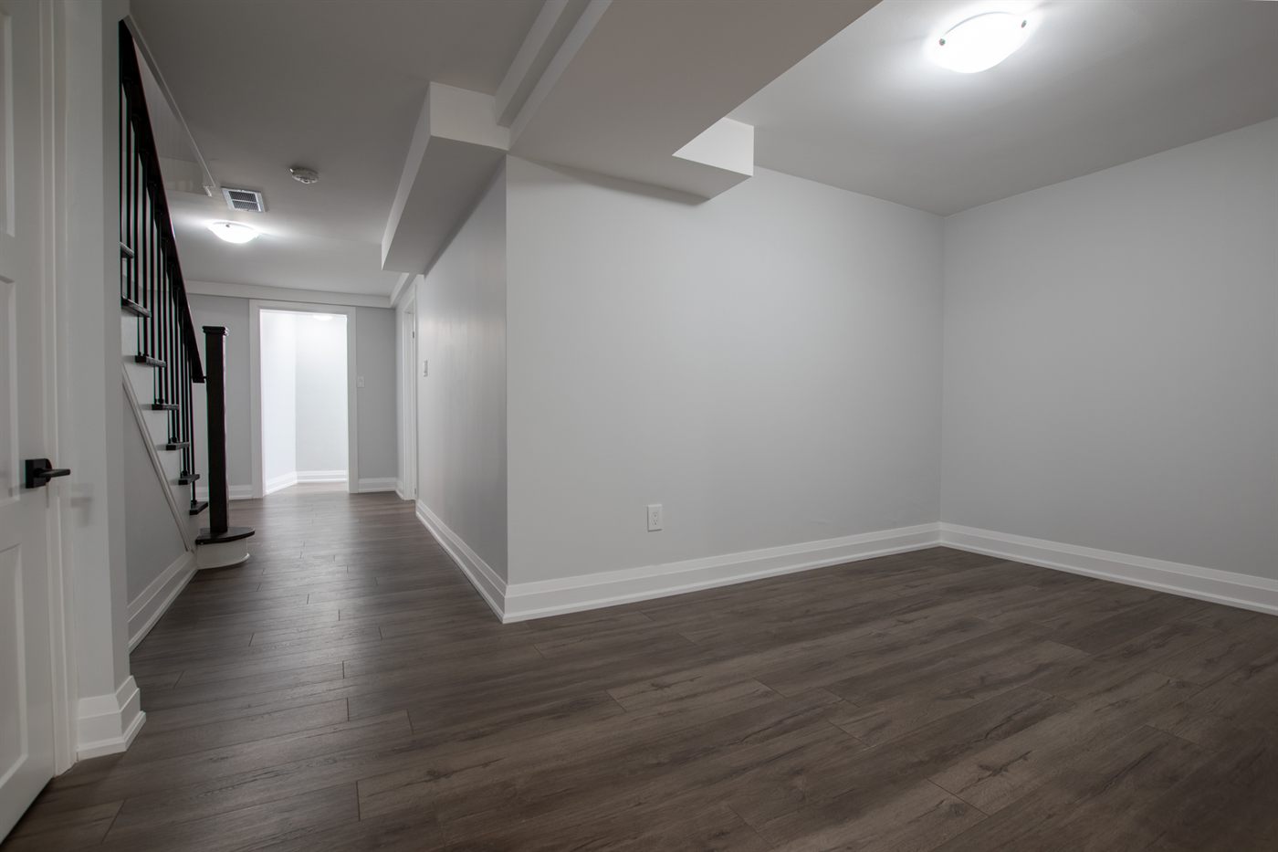 Finished basement with wood-look flooring and recessed lighting