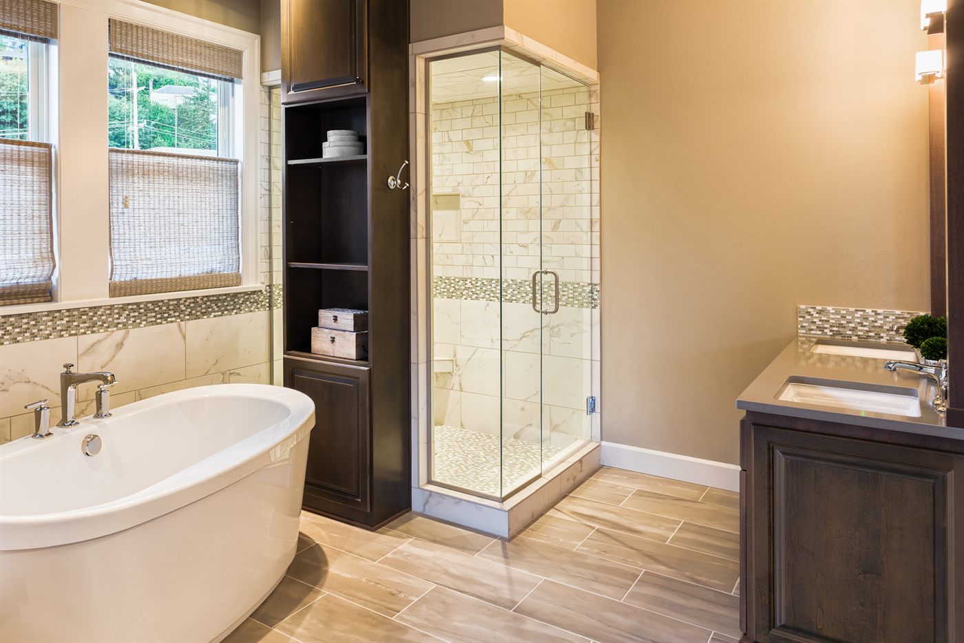 Renovated bathroom with freestanding soaking tub and tiled glass shower