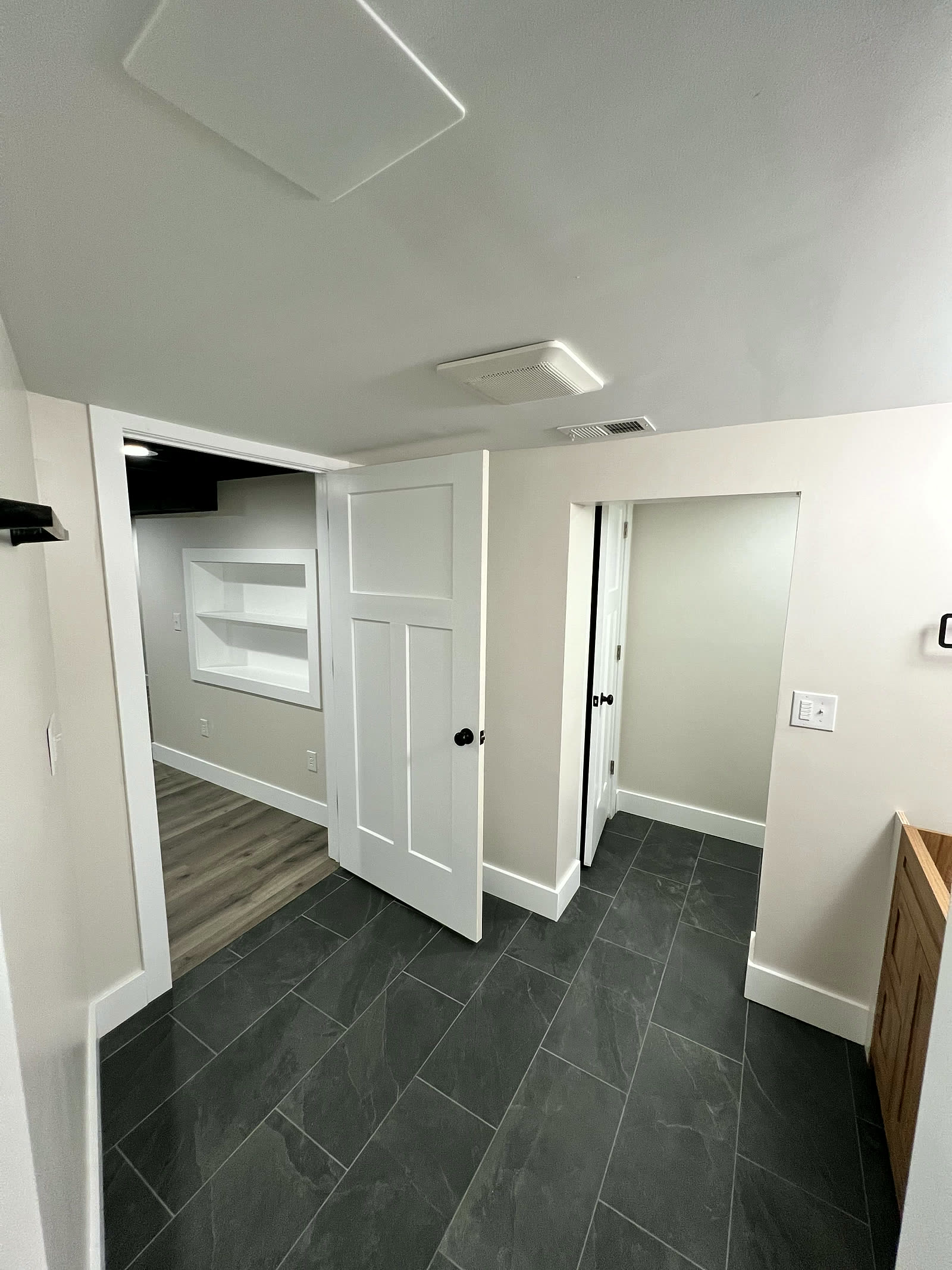 Finished basement room with built-in niche and doors