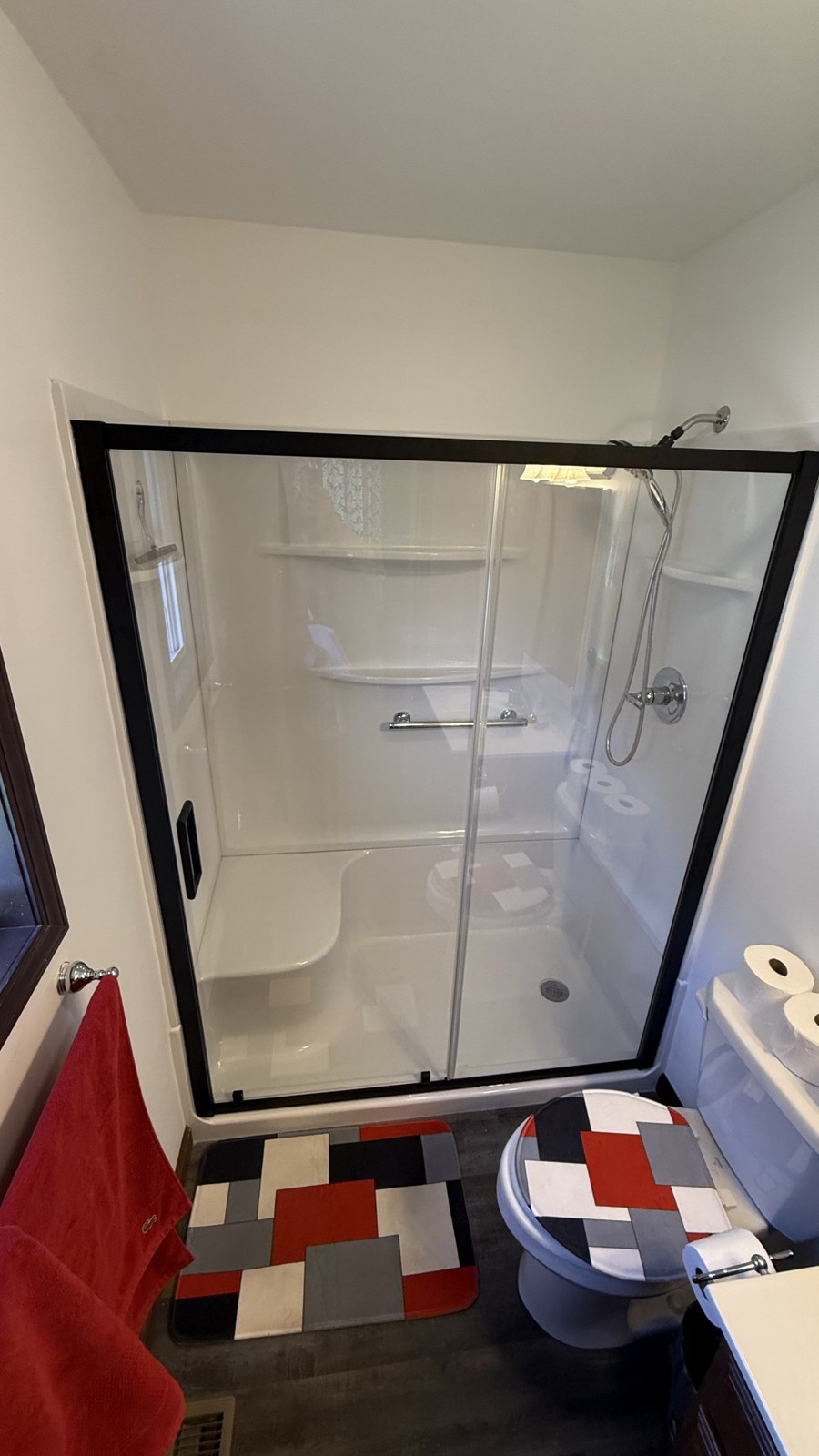 Bathroom after remodel — new glass shower enclosure and tile floor