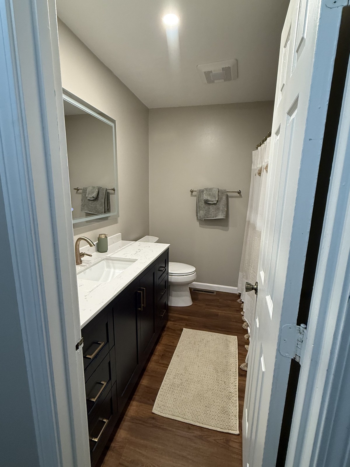 Bathroom after remodel — new vanity, mirror and flooring