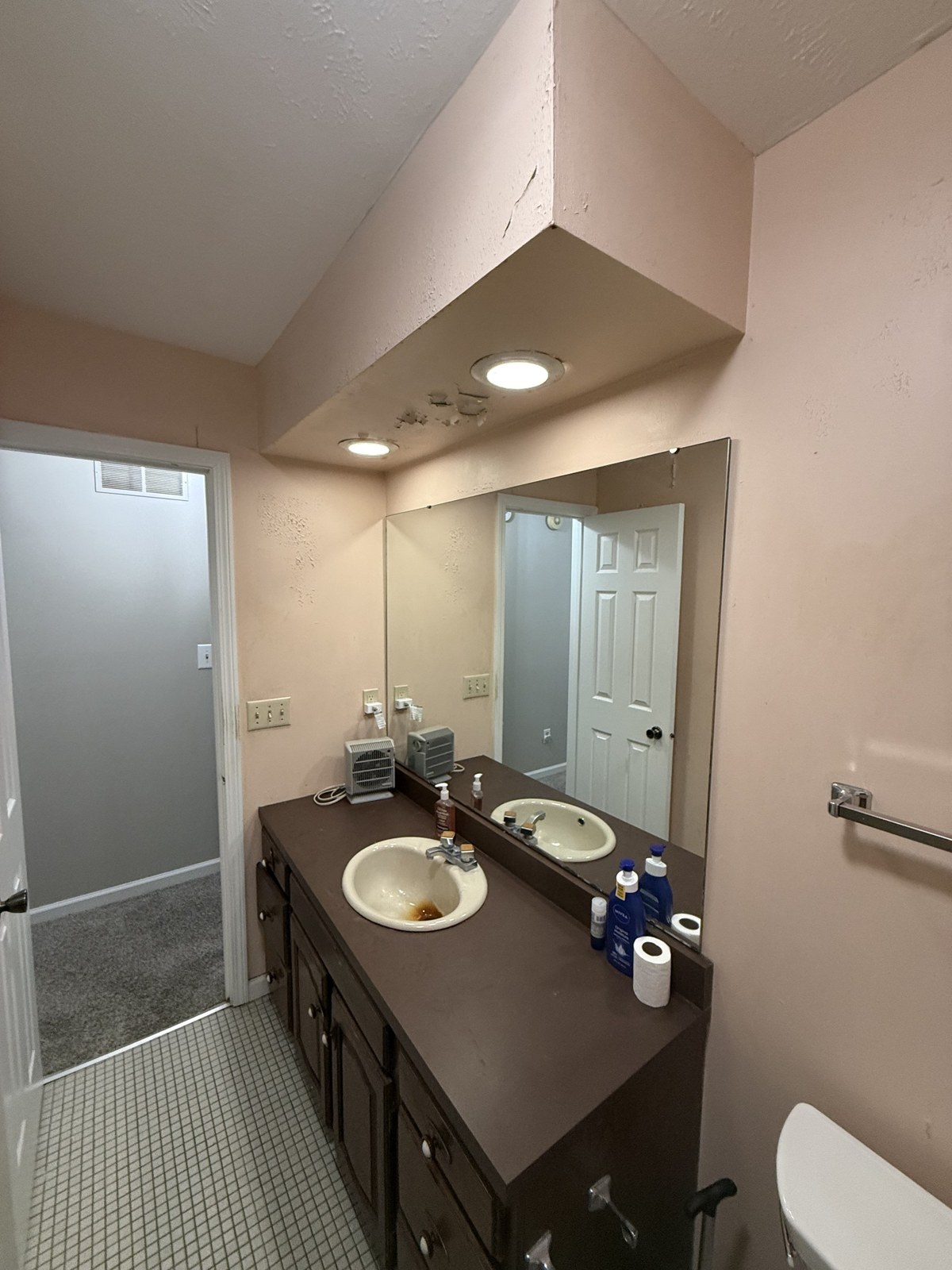 Bathroom before remodel — dated dark vanity and worn flooring