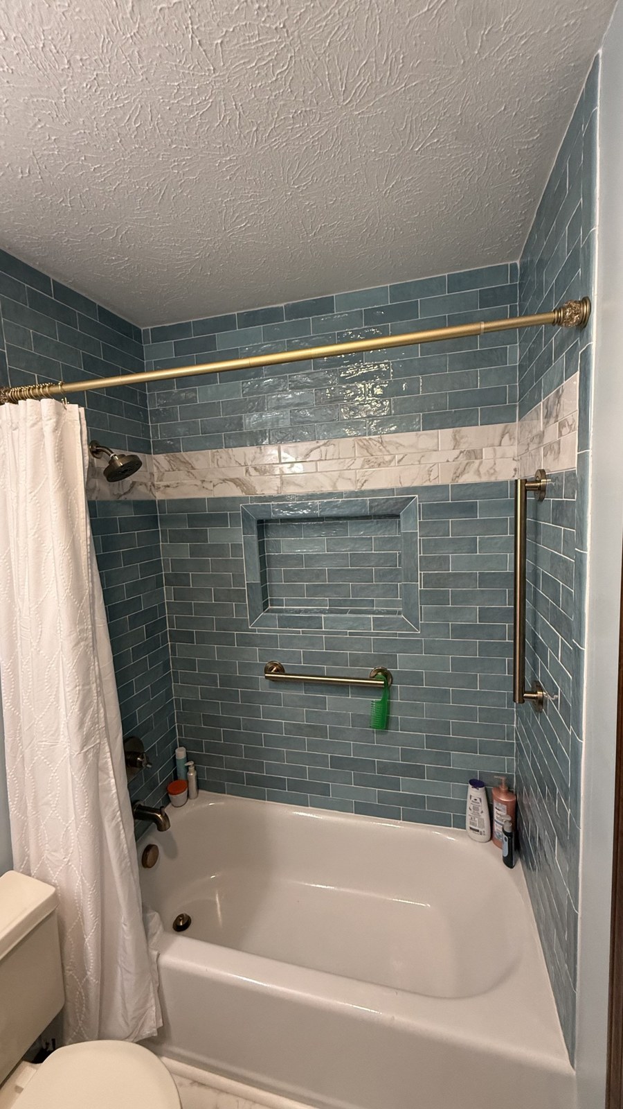Bathroom after remodel — new tiled tub surround and fixtures