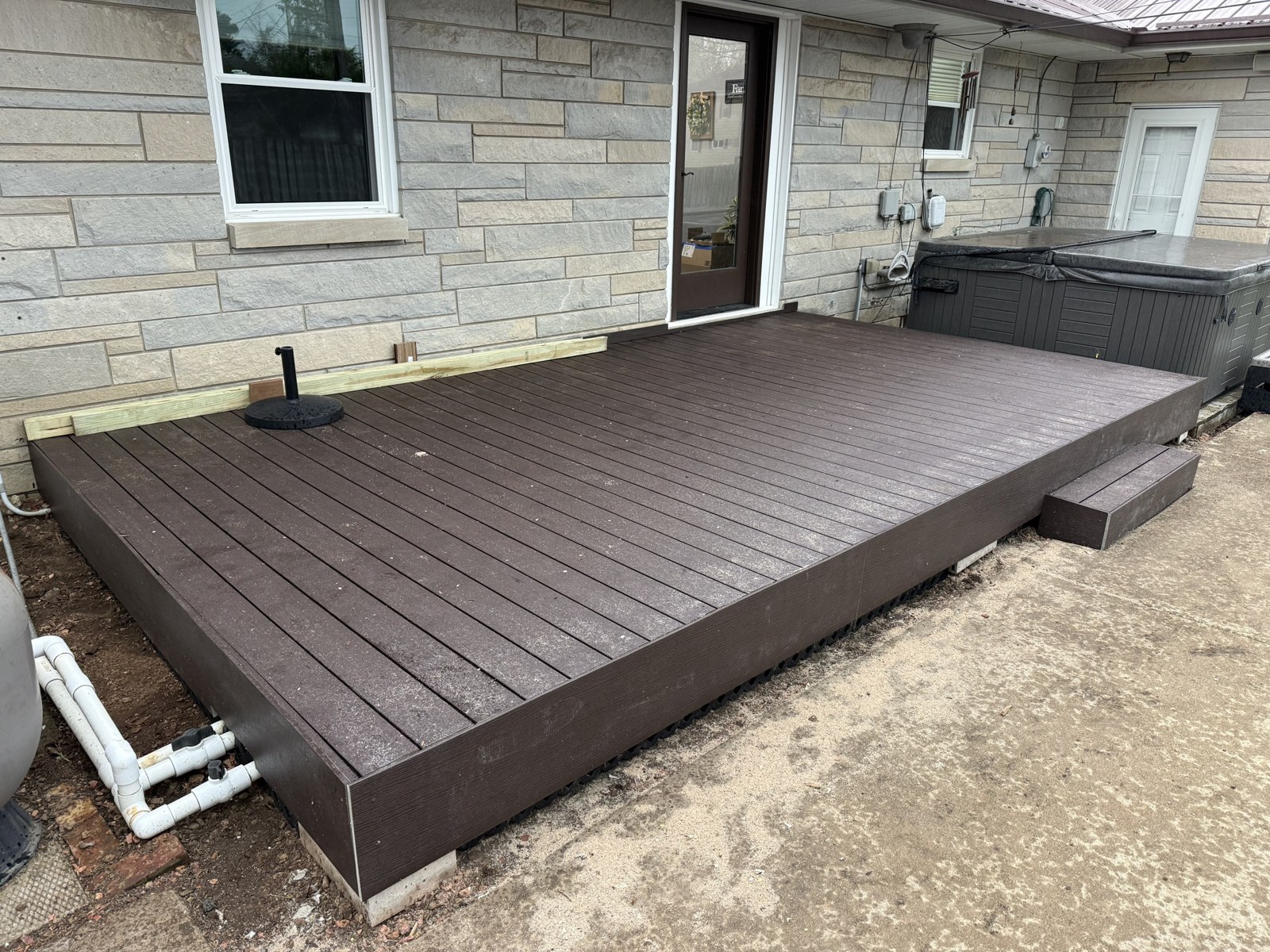 Deck after replacement — new composite decking along the house