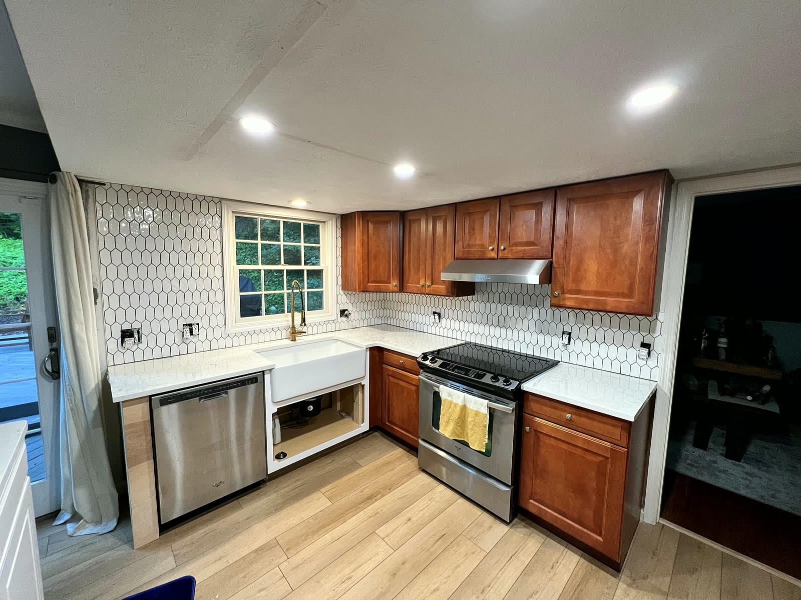 Warm wood cabinets with white counters and tile backsplash