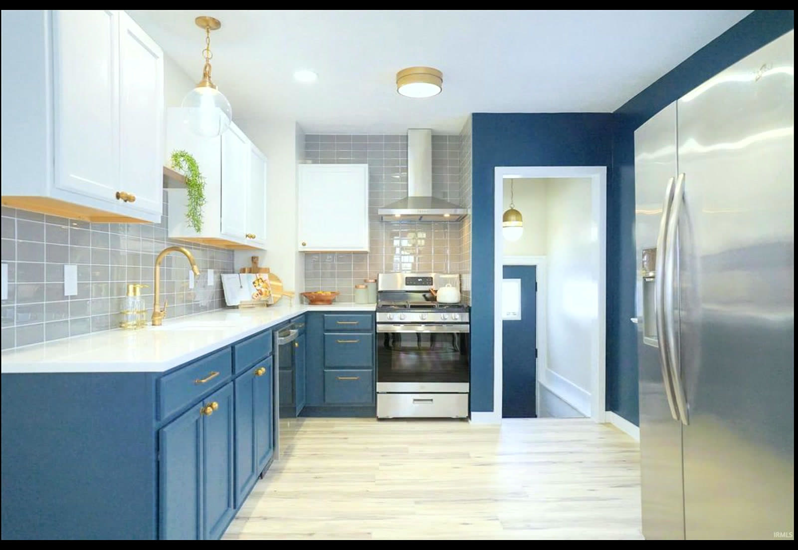 Blue-and-white kitchen with subway tile and gold faucet